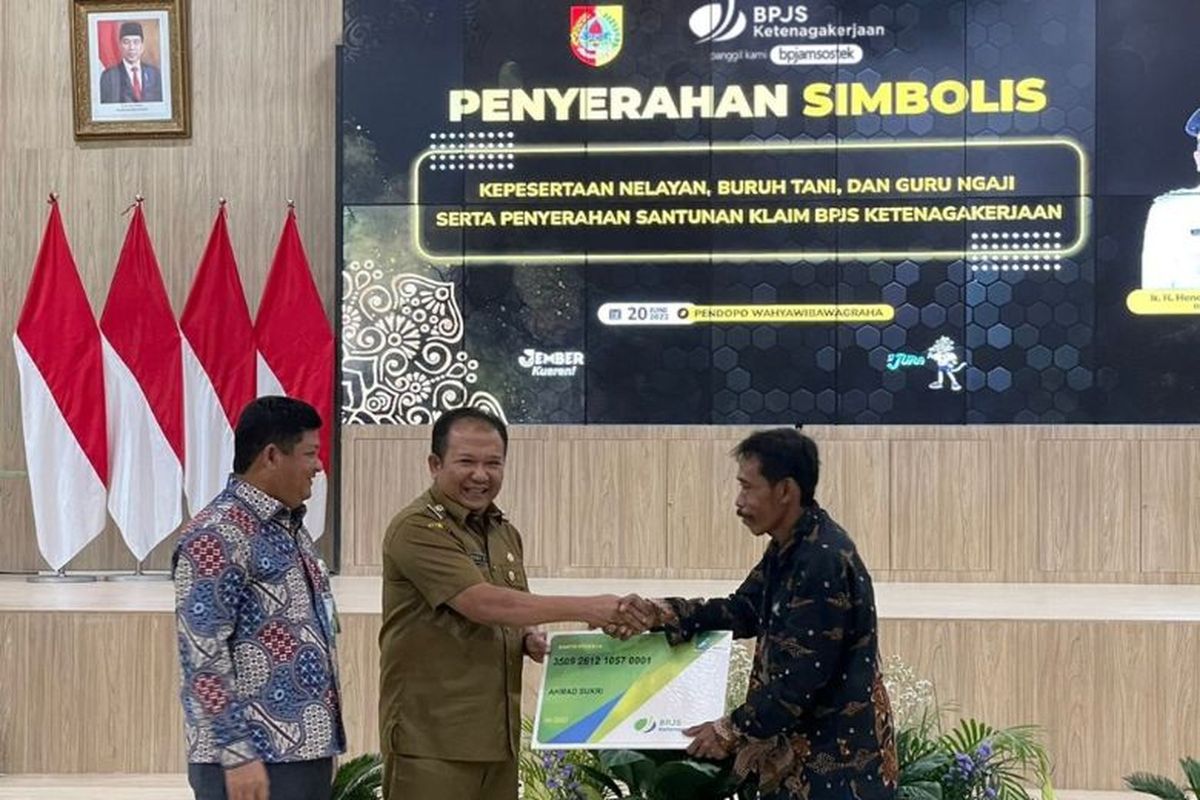 Direktur Kepesertaan BPJAMSOSTEK Zainudin menyaksikan penyerahan kartu peserta oleh Bupati Jember Hendy Siswanto kepada perwakilan peserta.