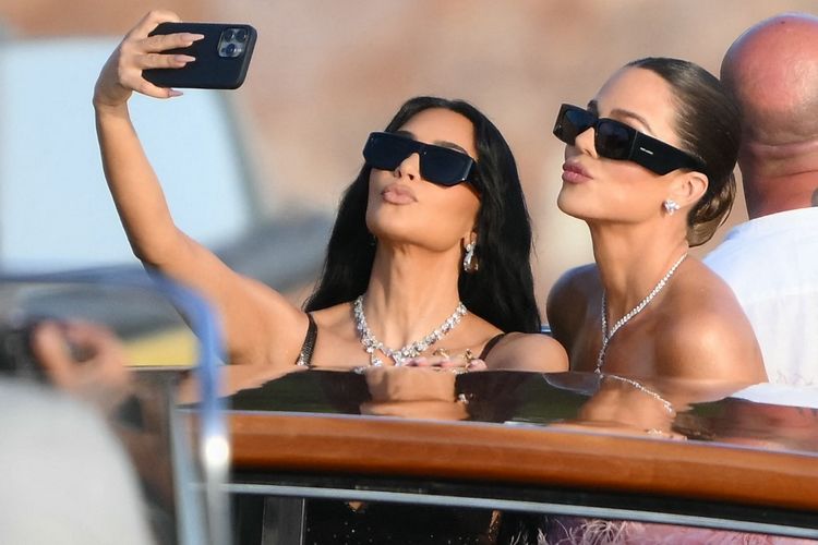 Kim Kardashian (kiri) berpose dengan Khloe Kardashian (kanan) saat menghadiri pernikahan Jeff Bezos dan Lauren Sanchez di Venesia, Italia, pada Jumat (27/6/2025).