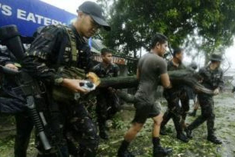 Tentara Filipina mengangkat pohon yang tumbang akibat diterjang topang Koppu.