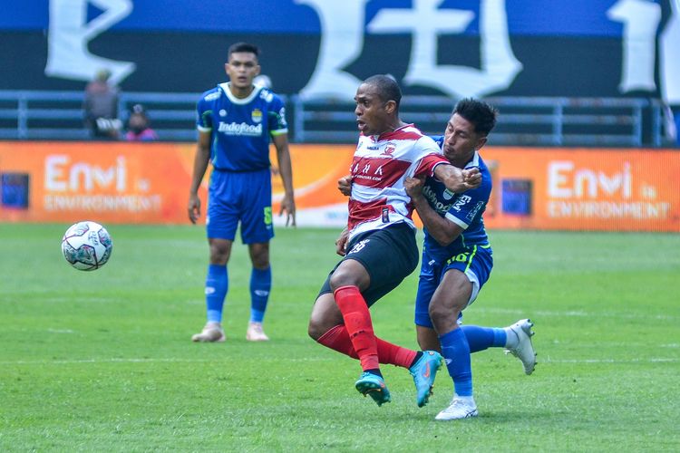 Penyerang Madura United Pedro Henrique Cortes, dihadang wing back Persib Daisuke Sato dalam duel Persib vs Madura United pada laga pekan kedua Liga 1 2022/2023, Sabtu (30/7/2022) di Stadion Gelora Bandung Lautan Api (GBLA).
