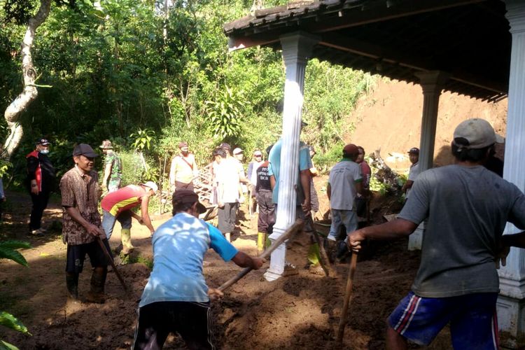 Warga desa bergotong royong membersihkan rumah warga yang tertimpa tanah yang longsor di Desa Balerejo, Kecamatan Wlingi, Kabupaten Blitar, Jumat (19/11/2021)