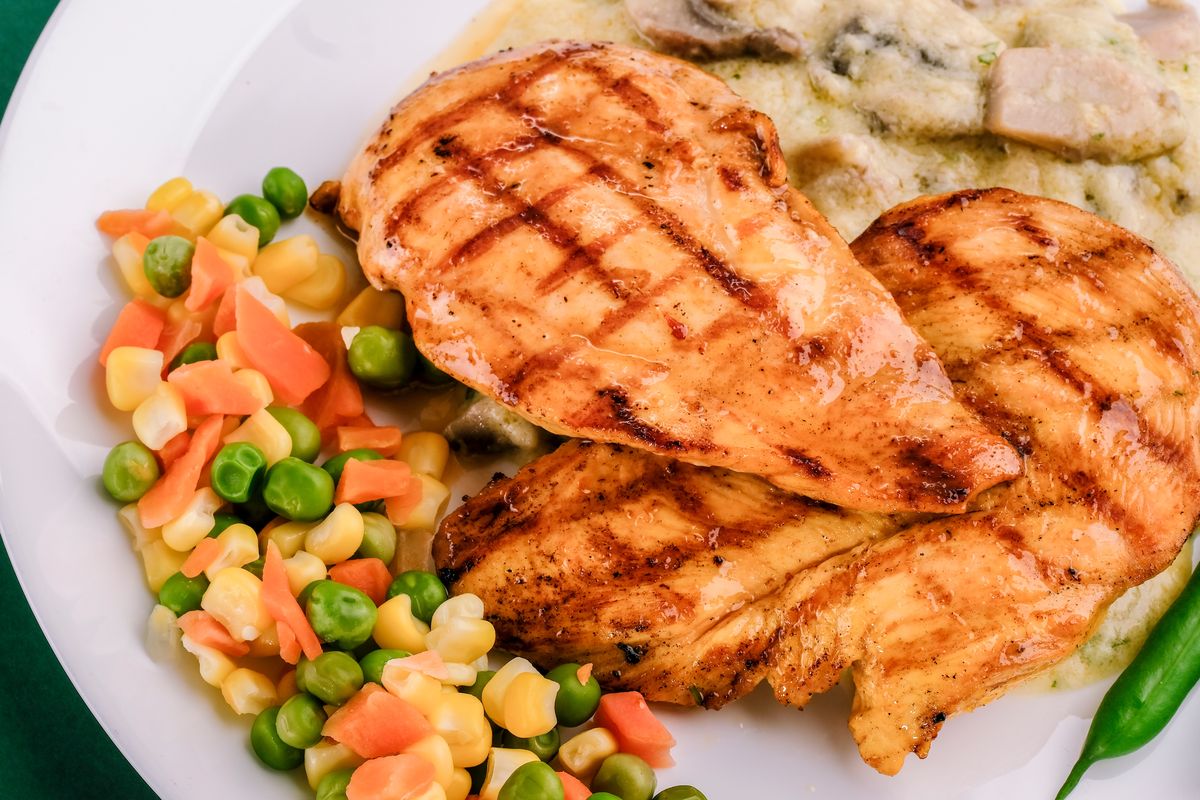 Ilustrasi steak ayam dengan mushroom sauce dan sayuran. 