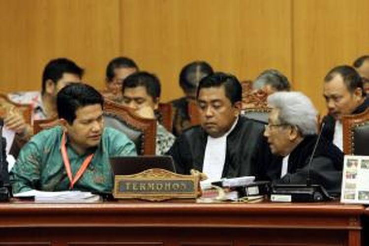 Ketua Komisi Pemilihan Umum (KPU), Husni Kamil Manik (kiri) berdiskusi dengan tim kuasa hukum, Adnan Buyung Nasution (kanan) dan Ali Nurdin saat sidang lanjutan di Gedung Mahkamah Konstitusi (MK), Jumat (8/8/2014). Agenda sidang kali ini adalah mendengarkan jawaban termohon, keterangan pihak terkait, dan Bawaslu terkait gugatan Pilpres 2014 oleh pasangan Prabowo-Hatta.