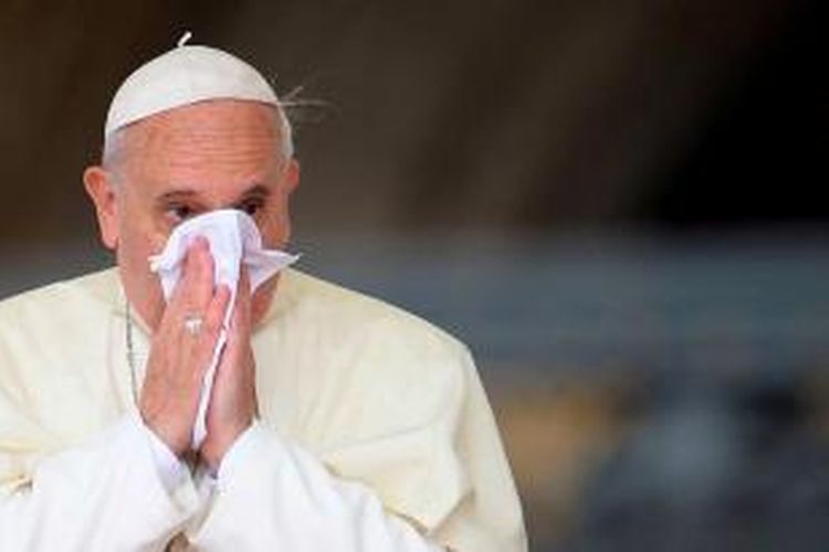 Paus Fransiskus menyeka hidung saat ia tiba untuk pertemuan umum mingguan di Alun-alun Santo Petrus di Vatikan, 9 Oktober 2013.