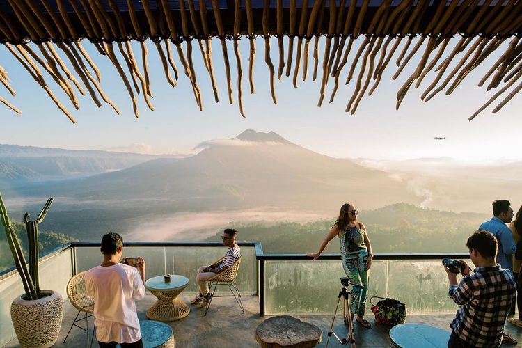 Para pengunjung Akasa Kintamani Coffee melihat pemandangan Gunung Batur yang cantik dari teras dengan balkon kaca