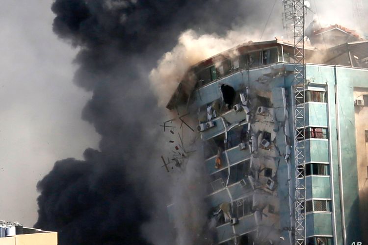 The Jala Tower building housing the offices of the Associated Press, Al-Jazeera and other media in Gaza City collapses after it was hit by an Israeli airstrike (15/5/2021). The attack came about an hour after the Israeli military warned people to evacuate the building 