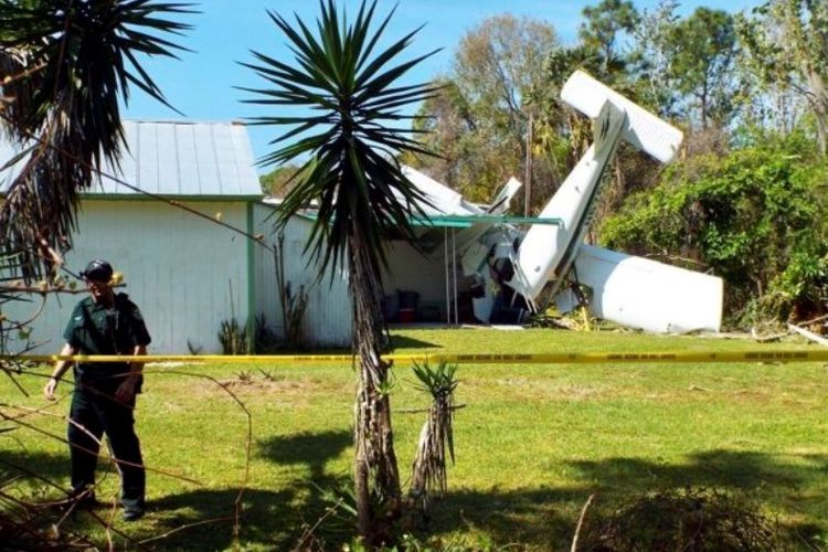 Petugas memasang garis pembatas di sekeliling lokasi jatuhnya pesawat terbang ringan di Florida, Selasa (6/3/2018).