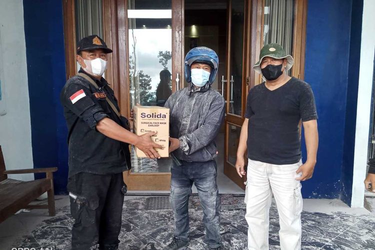 Sejumlah relawan membagikan masker kepada warga yang terdampak hujan abu vulkanis Gunung Merapi, di daerah Dukun, Kabupaten Magelang, Jawa Tengah, Sabtu (11/3/2023).