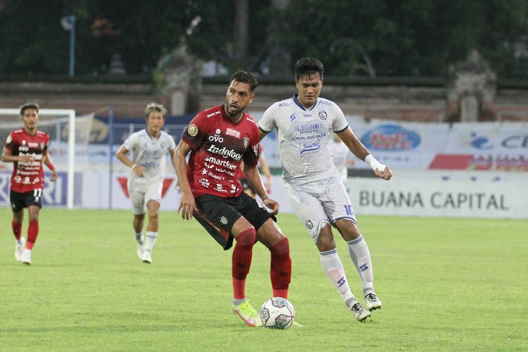 Willian Pachecho (kiri) berduel dengan Muhammad Rafli (kanan) pada laga pekan ke-31 Liga 1 yang mempertemukan Bali United Vs Arema FC di Stadion Gelora Ngurah Rai, Denpasar, Bali, Selasa (15/3/2022).