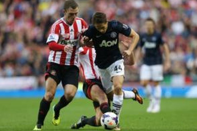 Gelandang muda Manchester United, Adnan Januzaj (biru), mendapat pengawalan ketat dari dua pemain Sunderland, Craig Gardner (kiri) dan Lee Cattermole (belakang), pada laga di Stadium of Lights, Sabtu (5/10/2013).