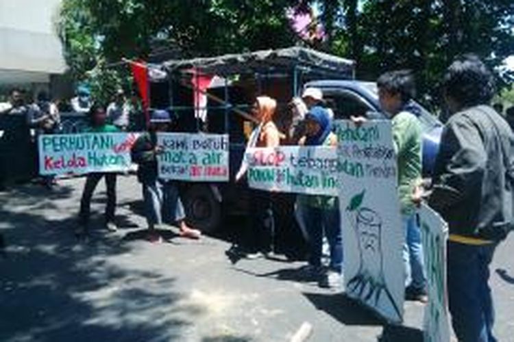 Aktifis lingkungan menggelar aksi di depan kantor Perum Perhutani Unit II Surabaya.