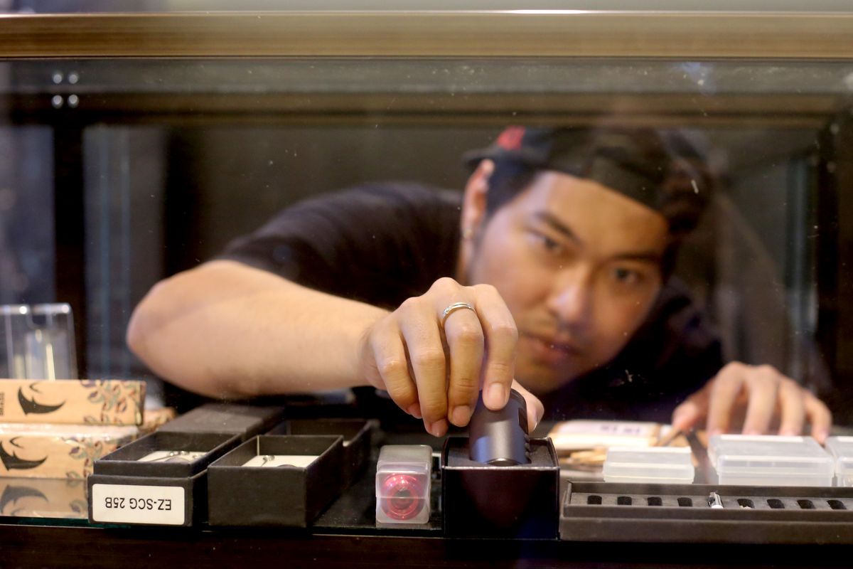 Cesley R Mogot salah satu distributor kebutuhan tattoo menunjukkan salah satu mesin tattoo.