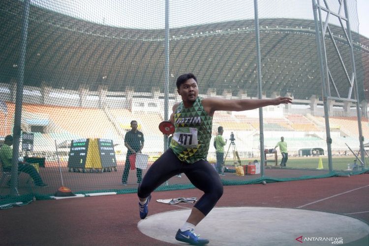 Seorang atlet lempar cakram sedang melakukan lemparan cakram