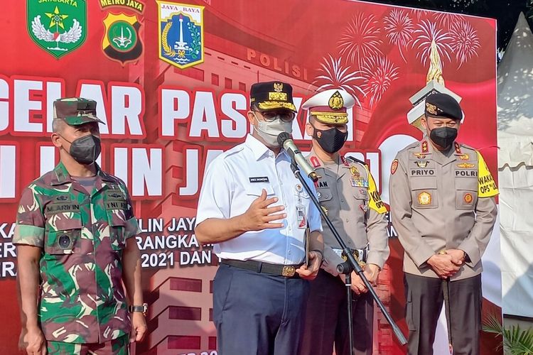 Gubernur DKI Jakarta Anies Baswedan (tengah) saat upacara apel pasukan Operasi Lilin 2021 di Mapolda Metro Jaya, Kamis (23/12/2021).