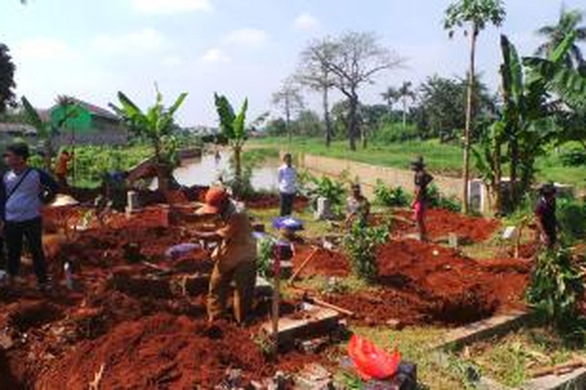 Petugas makam TPU Kampung Bayur, di Cipinang Melayu, Jakarta Timur menggali kembali makam lama yang terkena dampak pelebaran untuk normalisasi Kali Sunter. Jumat (16/5/2014).