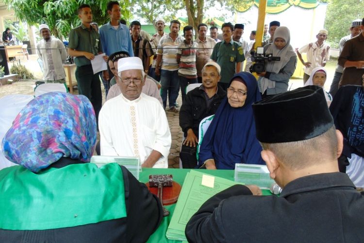 Ishak bin Tgk Cut Ben (88) dan istrinya Latifah (83) mengikuti prosesi pencatatan pernikahan di depan kantor camat  Nisam Antara, Kabupaten Aceh Utara, Senin (17/9/2018). 