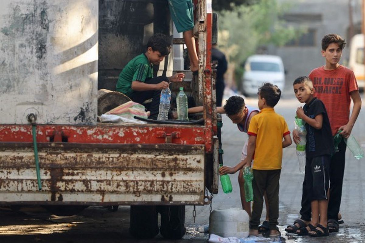 Anak-anak laki-laki Palestina mengisi air minum ke botolnya dari kendaraan isi ulang di Rafah, selatan Jalur Gaza, Rabu (18/10/2023).