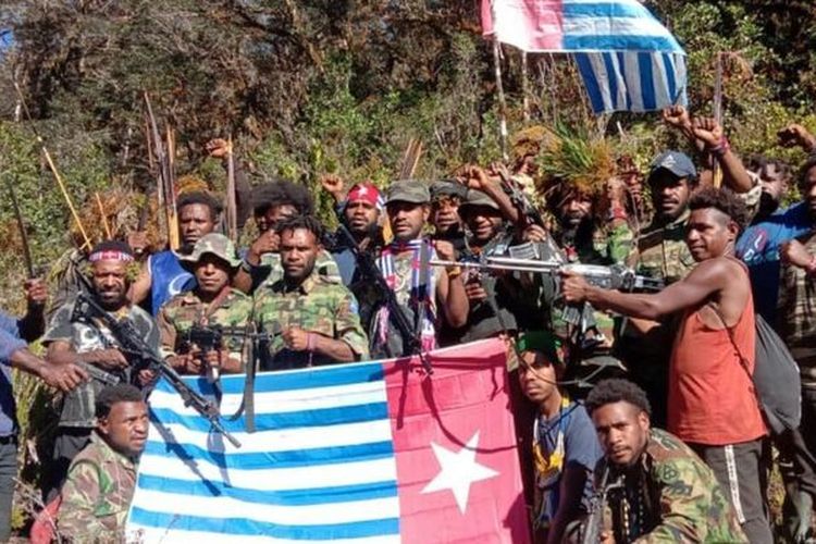 Anggota Tentara Pembebasan Nasional Organisasi Papua Merdeka memegang bendera Bintang Kejora.