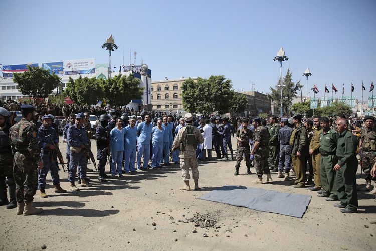 Pasukan dari kepolisian berjaga di depan sembilan pria yang diduga terlibat dalam pembunuhan pejabat senior Houthi, Saleh al-Samad, dalam proses eksekusi mati di Lapangan Tahrir, Sanaa, Yaman, pada Sabtu 18 September 2021.