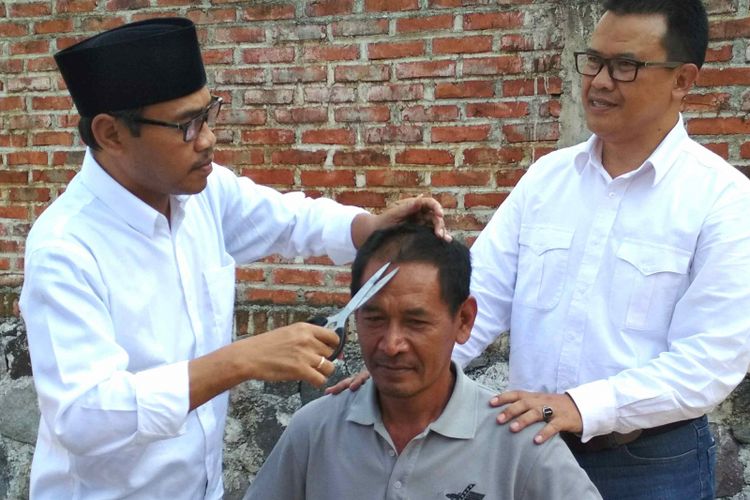 Al Khadziq calon terpilih bupati Temanggung (kiri) sedang mencukur rambut Parilah yang sebelumnya bernazar ingin digunduli Khadziq jika menang Pilkada Temanggung 2018, Kamis (26/7/2018).