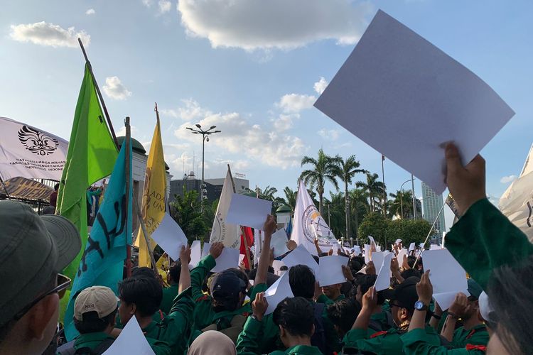 Mahasiswa membentangkan kertas putih kosong sebagai bentuk kemarahan atas disahkannya KUHP oleh DPR bersama pemerintah pada aksi unjuk rasa yang digelar di depan Gedung DPR/MPR RI, Jakarta Pusat, Kamis (15/12/2022).
