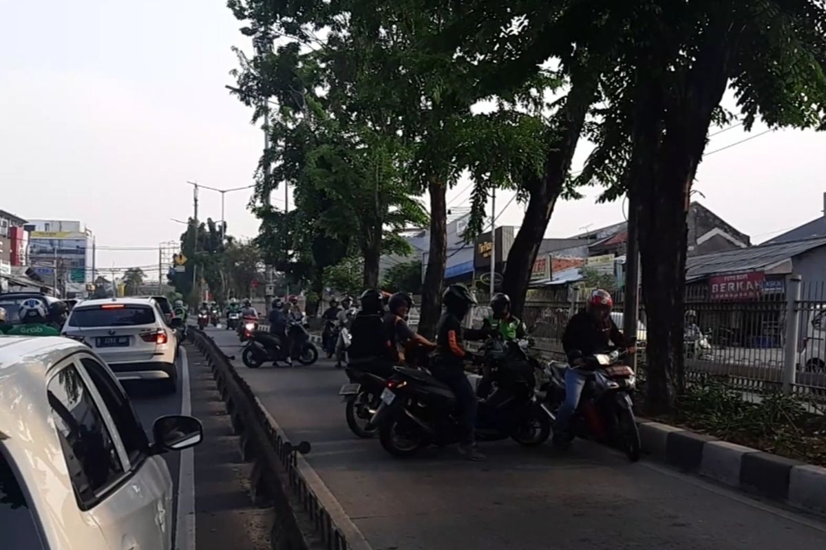 Pengendara motor yang masuk jalur bus Transjakarta berusaha memutar balik sebab mengetahui ada aparat kepolisian yang telah berjaga di ujung jalur untuk menilang para pengendara 