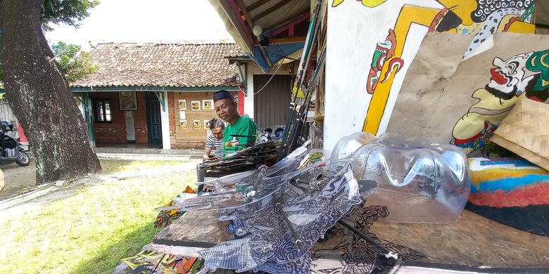 Iskandar saat memotong mengecat Wayang Uwuh yang terbuat dari Plastik, Jumat (13/1/2023)