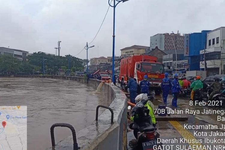 Suku Dinas Penanggulangan Kebakaran dan Penyelamatan (Sudin Gulkarmat) Jakarta Timur tengah melakukan penyedotan air dari ruas jalan Jatinegara Barat, Jakarta Timur, menuju Kali Ciliwung yang berada di sisi jalan, Senin (8/2/2021).