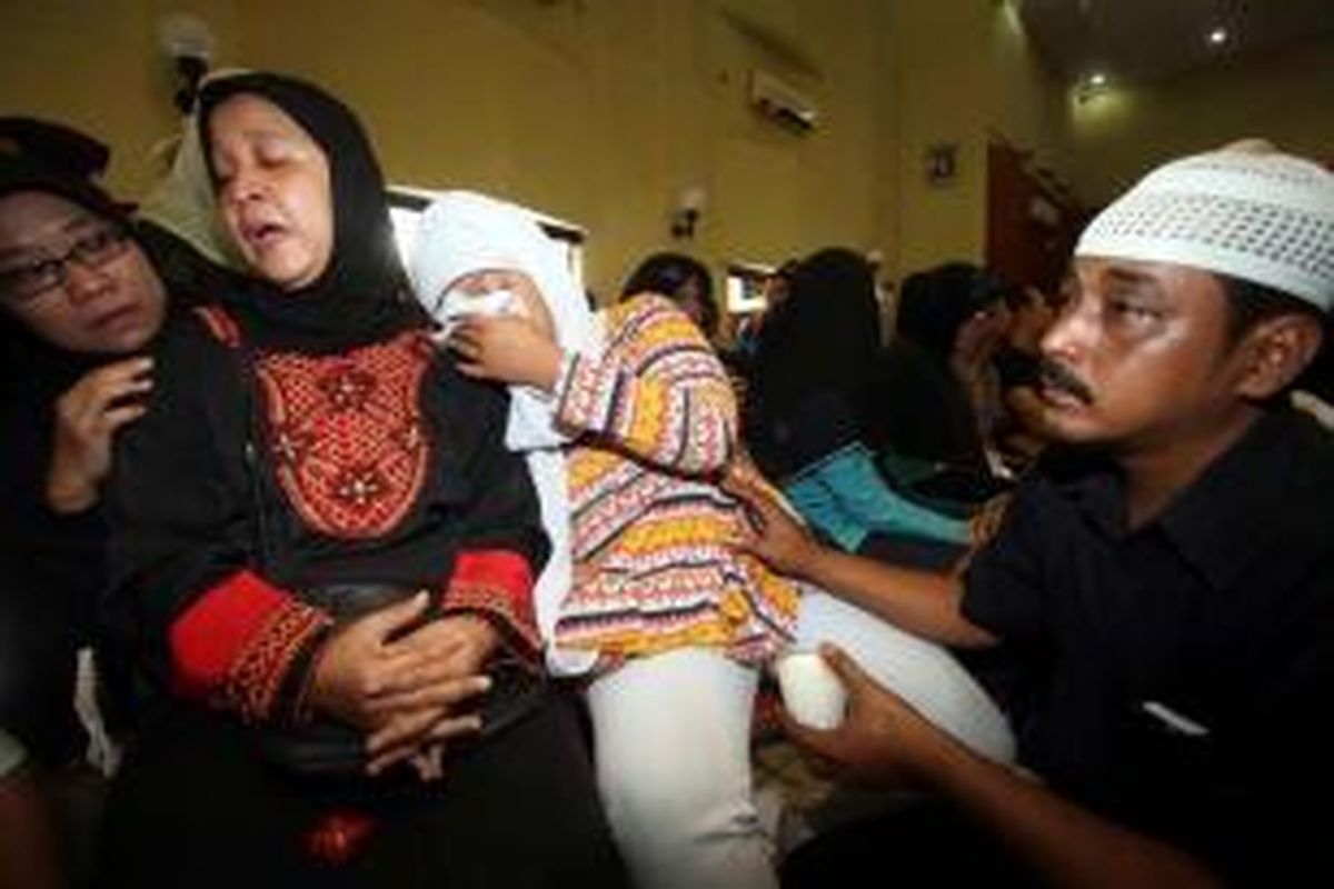 Istri polisi korban penembakan Tirta Sari (dua kiri) dan putrinya Devi Novita Sari (dua kanan) dihibur keluarga di depan jenazah Bripka Sukardi yang disemayamkan di Gedung Sanggita Asrama Mabes Polri Cipinang, Jakarta Timur, Rabu (11/9/2013).