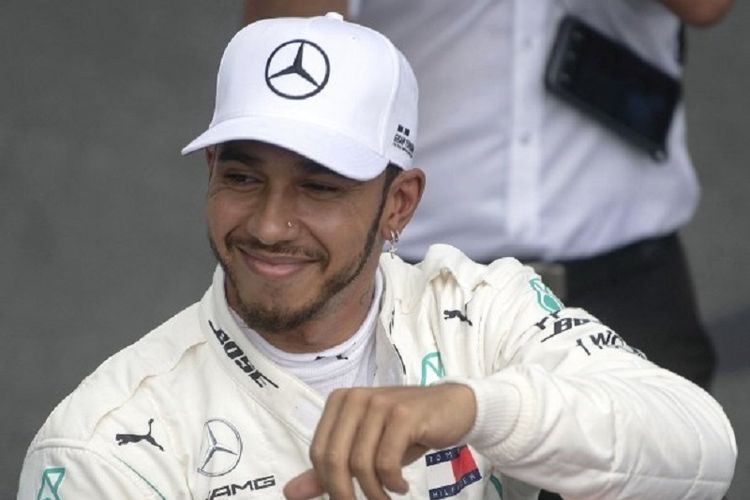 Pebalap Mercedes, Lewis Hamilton, merayakan keberhasilannya meraih pole position pada GP Brasil, 10 November 2018. 