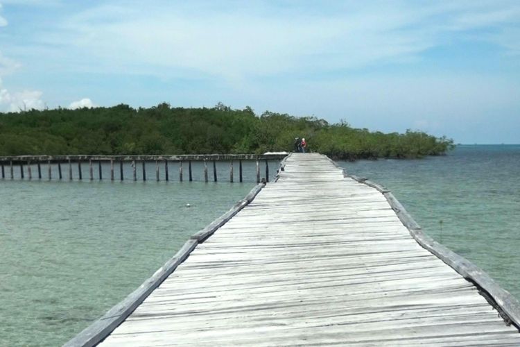 Jembatan kayu yang menghubungkan daratan Pulau Kelapan dengan dermaga kapal. Pulau Kelapan berada di Kabupaten Bangka Selatan, Kepulauan Bangka Belitung.