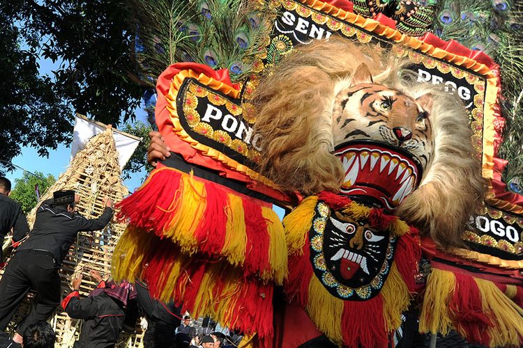 Seniman menampilkan tari Reog Ponorogo saat warga berebut ketupat dalam Festival 1.001 Ketupat di Desa Kalimalang, Ponorogo, Jawa Timur, Senin (10/6/2019). Kegiatan tersebut dilakukan oleh warga setempat untuk menyambut tradisi Lebaran Ketupat serta untuk mempererat persaudaraan warga.