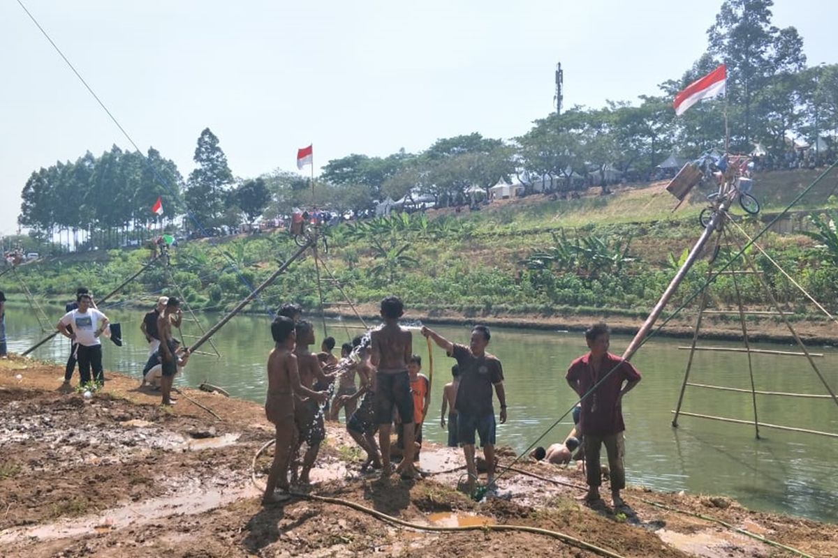 Sorak-sorai lomba panjat pinang di saluran Kanal Banjir Timur (KBT), Pondok Kopi, Kecamatan Duren Sawit, Jakarta Timur, Minggu (18/8/2019).