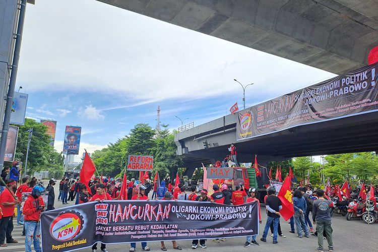 Massa buruh yang memakai kostum pakaian merah memadati kawasan Fly Over, Kota Makassar, Sulsel, Rabu (1/5/2024).