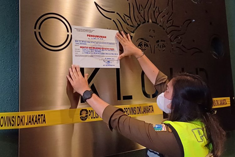 Petugas Satpol PP DKI saat memasang stiker penyegelan di Kafe Kloud Sky Dining & Lounge, Senopati, Jakarta Selatan, Selasa (28/11/2023).