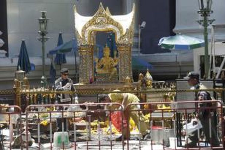 Polisi dan petugas yang berwenang bekerja di dekat patung Phra Phrom sehari setelah ledakan besar yang terjadi dekat Kuil Erawan, di kawasan Rajprasong, Bangkok, Thailand, Selasa, 18 Agustus 2015. Puluhan orang tewas akibat ledakan tersebut.
