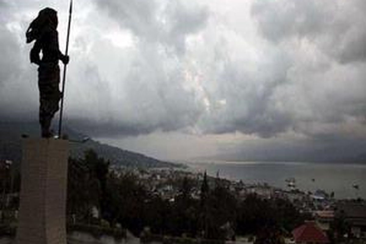 Lansekap kota Ambon dengan latar belakang Teluk Ambon serta latar depan patung pahlawan nasional dari Maluku, Martha Christina Tiahahu diabadikan dari kawasan Karang Panjang, Ambon, Maluku, Minggu (24/6). 