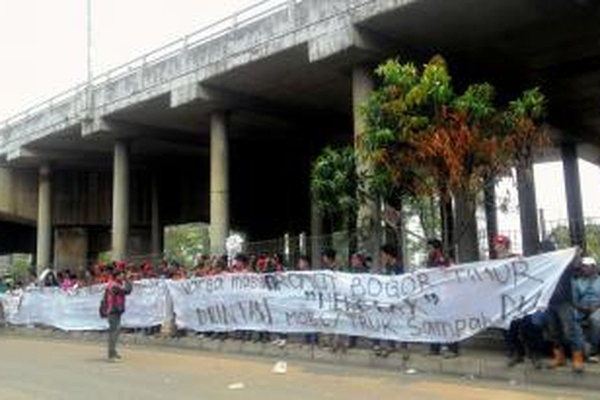 Warga Cileungsi, Kabupaten Bogor, berdemo di Jalan Transyogi, Cileungsi, menolak keberadaan truk-truk sampah milik Pemprov DKI Jakarta yang melintas di jalur tersebut, Selasa (3/11/2015).
