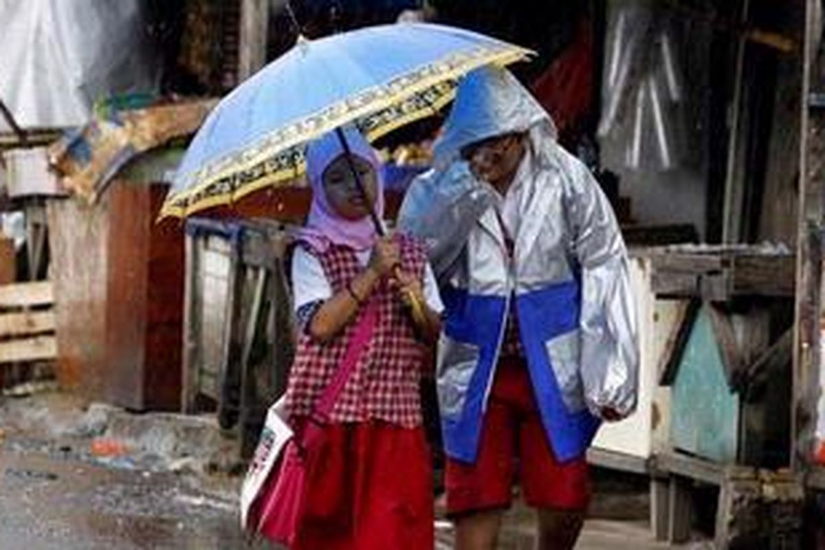 Dua bocah menembus hujan gerimis di kawasan Petamburan, Jakarta Barat, Selasa (26/10/2010). 