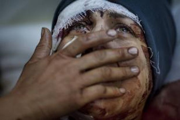 FILE - Aida menangis saat ia pulih dari cedera parah setelah tentara Suriah menembaki rumahnya di Idlib, Suriah utara, 10 Maret 2012. Suami dan dua anaknya tewas dalam serangan itu. Foto ini salah satu dari 20 foto karya fotografer AP yang memenangkan Pulitzer Prize 2013 kategori foto Breaking News.