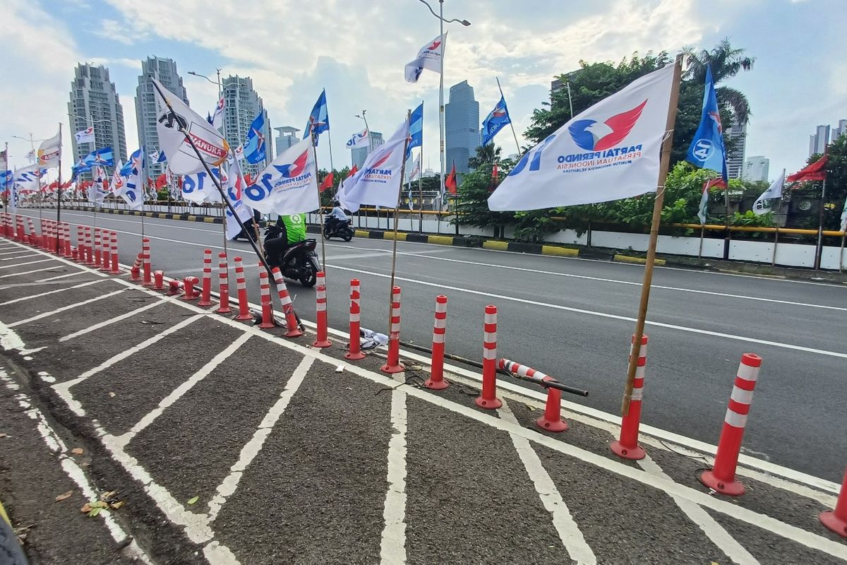 Sejumlah bendera partai terpasang di “stick cone” jalur sepeda, Jembatan Ciliwung Cokroaminoto, Jakarta Selatan.
