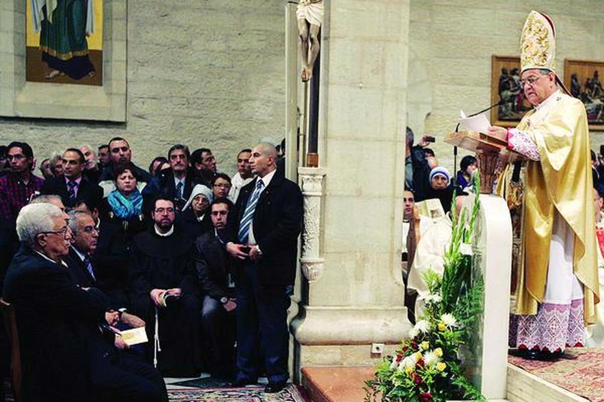 Presiden Palestina Mahmoud Abbas (kiri) hadir dalam misa Natal yang diadakan di gereja yang dipercaya sebagai tempat kelahiran Yesus di Bethlehem, Tepi Barat, Minggu (25/12) pagi.