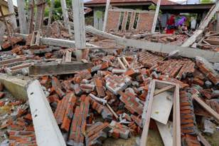 Situasi rumah yang runtuh akibat gempa di Desa Kuta Pangwa, Kecamatan Trienggadeng, Pidie Jaya, Aceh, Jumat (9/12/2016). Desa Kuta Pangwa adalah titik desa terparah dan menyebabkan puluhan rumah warga hancur dan memakan 15 orang dari 9 kepala keluarga.


