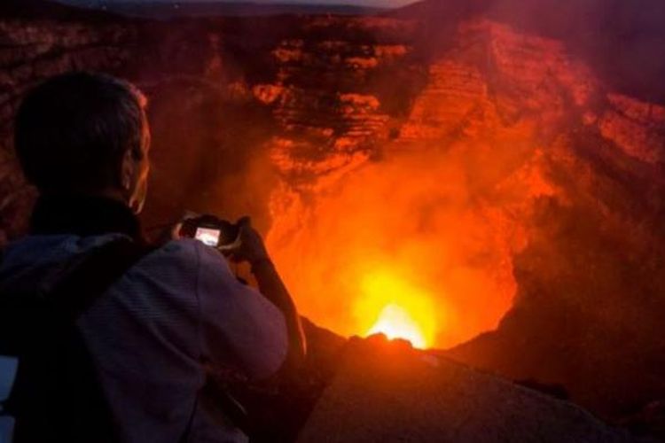 Seorang turis mengambil foto danau lava di dalam kawah gunung Masaya di Nikaragua.
