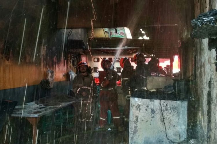 Petugas Diskar PB Kota Bandung tengah melakukan pendinginan terhadap bangunan rumah makan padang di Jalan Inhoftank, yang terbakar disebabkan oleh kompor gas meledak