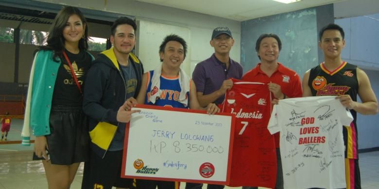 mantan pebasket Satya Wacana LBC Angsapura Salatiga (sekarang Satya Wacana Metro LBC Bandung), Jerry Lolowang (tengah, kemeja ungu) menerima jersey serta sejumlah uang hasil pertandingan eksibisi antara timnas basket putri melawan Happy Ballers yang digagas oleh Augie Fantinus (ketiga dari kiri), di Hall Basket Senayan, Jakarta, Rabu (27/11/2013). 