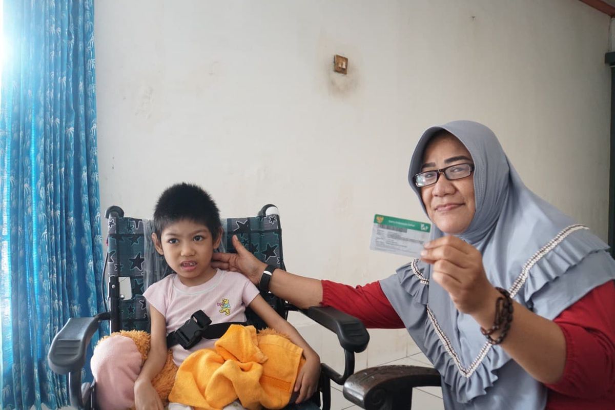 Peserta BPJS Kesehatan Endang Sari Banun bersama cucunya yang mengidap penyakit kelumpuhan otak bersyukur dengan adanya program JKN-KIS, Kamis (20/11/2020).