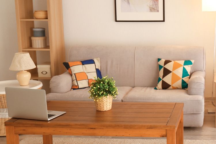 Ilustrasi ruang tamu dengan sofa abu-abu dan meja kayu