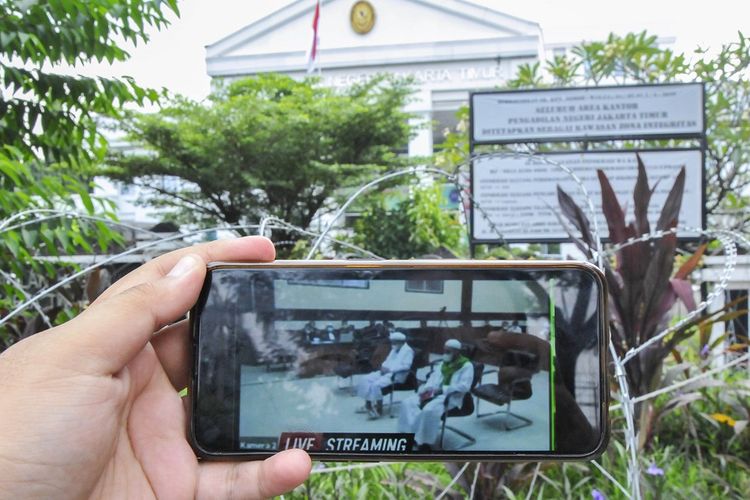 Jurnalis mengamati layar telefon pintar sidang Rizieq Shihab yang beragendakan tuntutan dari Jaksa Penuntut Umum (JPU) di Pengadilan Negeri Jakarta Timur, Kamis (3/6/2021). Pada sidang tersebut JPU menuntut Rizieq Shihab pidana penjara selama enam tahun untuk kasus tes usap RS UMMI, Bogor. ANTARA FOTO/ Fakhri Hermansyah/foc.