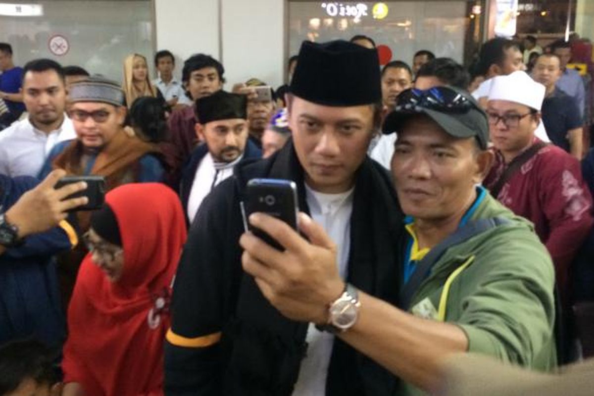 Calon gubernur DKI Jakarta, Agus Harimurti Yudhoyono disambut selawat dan jadi rebutan selfie oleh sejumlah relawan pendukung saat baru tiba di Bandara Internasional Soekarno-Hatta setelah menunaikan ibadah Umrah di Mekkah, Senin (13/2/2017).